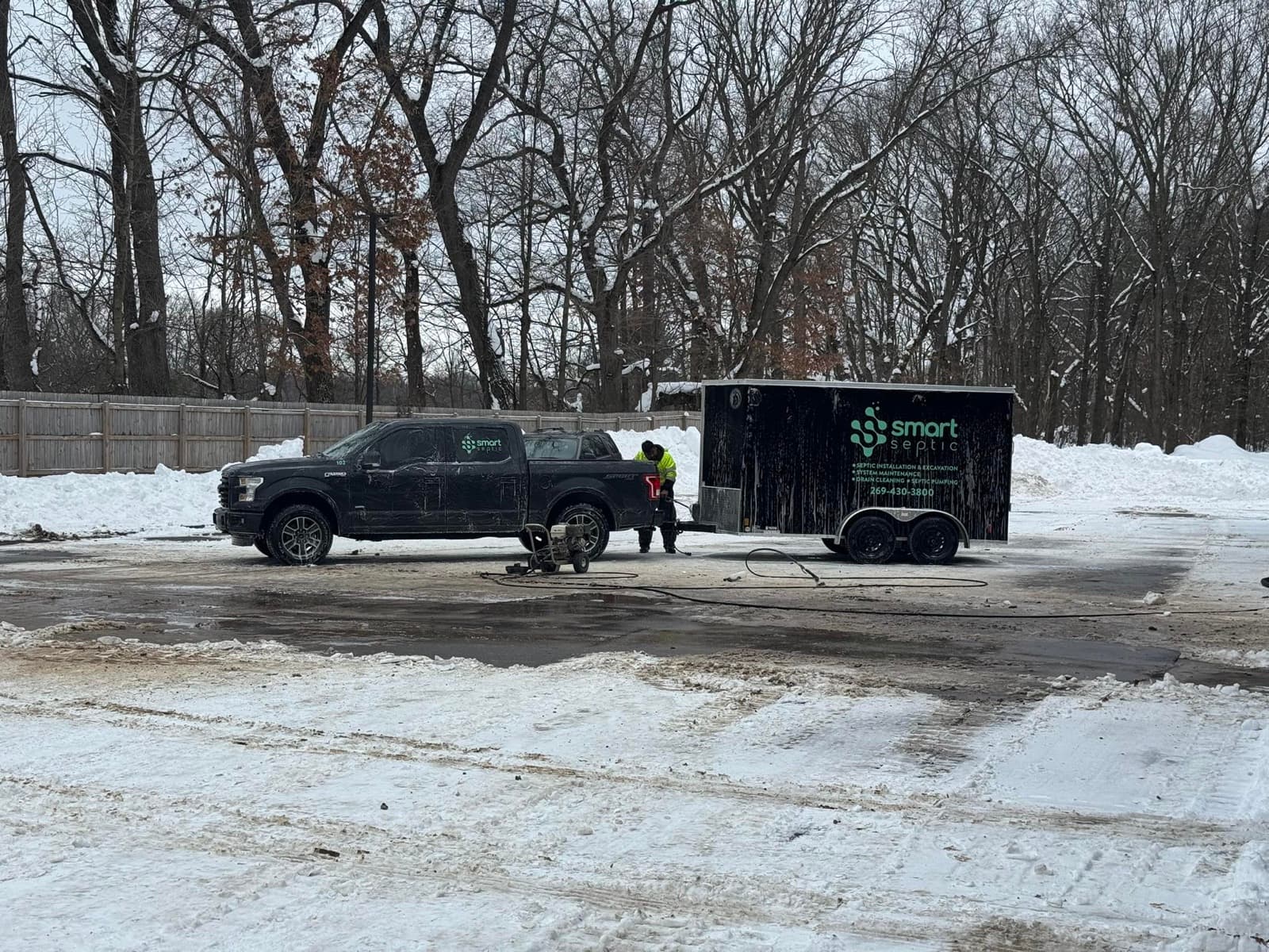 Crew at a winter job site with a Smart Septic trailer and Ford F-150