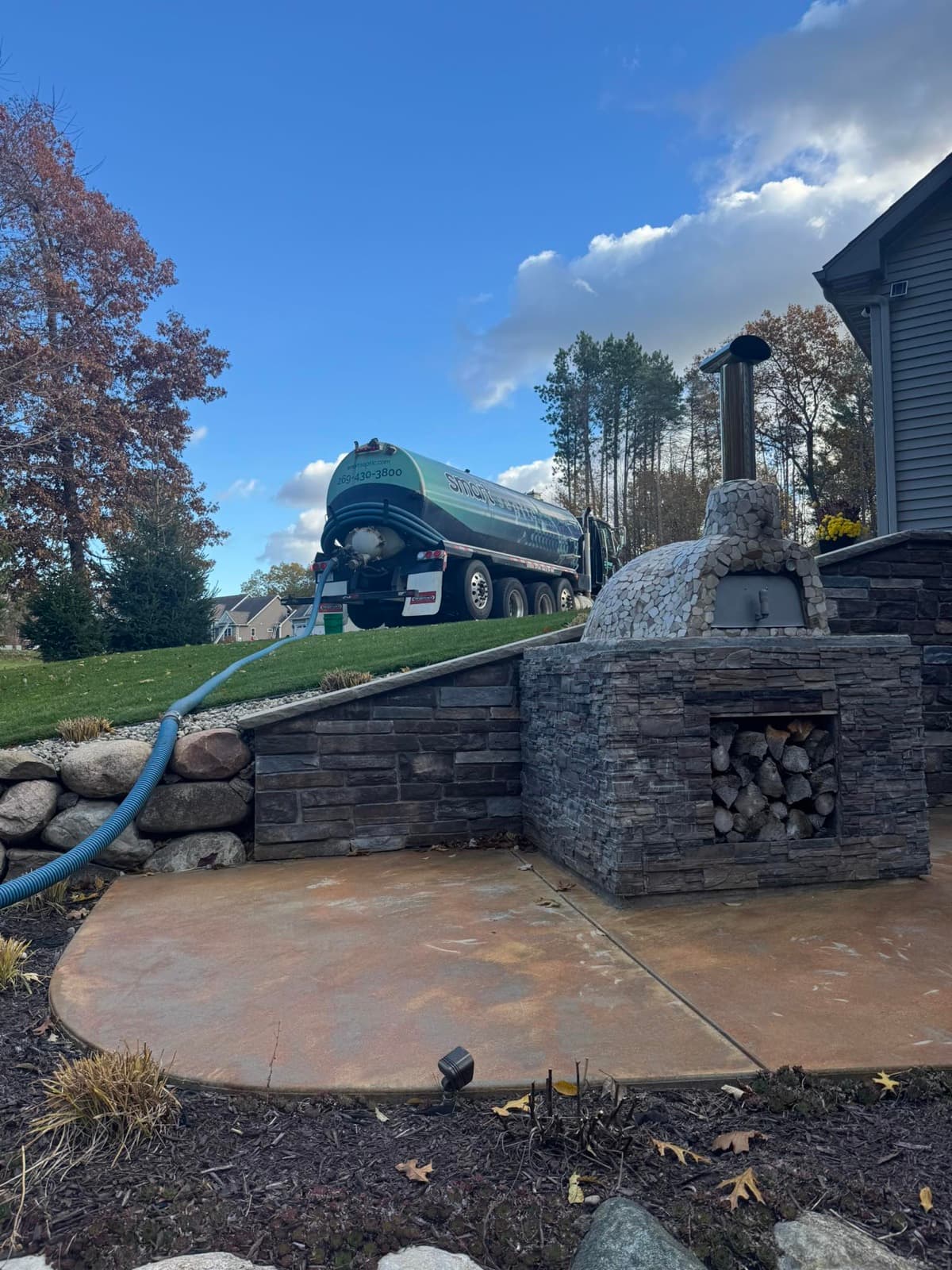 Smart Septic tanker working at a home with stone patio