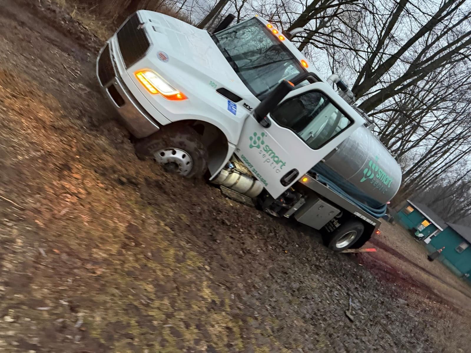 White Smart Septic pumping truck on a rural service road